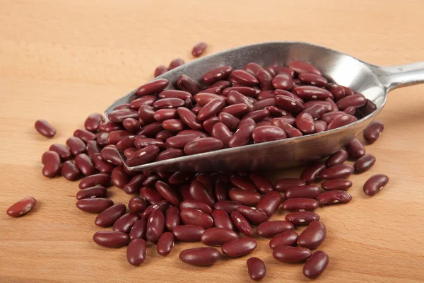 Red kidney beans with scoop on wood table — Stock Photo, Image