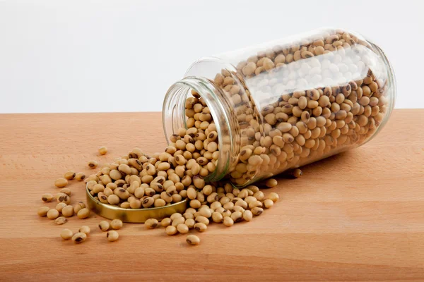 Soybean in a jar with lid off on wood table — Stock Photo, Image