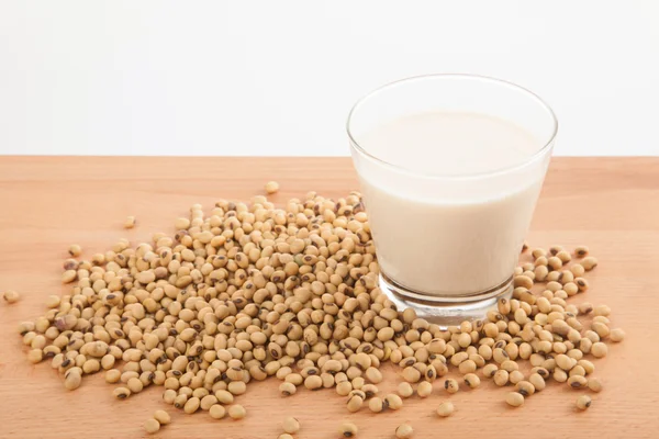 Soy milk in glass with soybeans — Stock Photo, Image