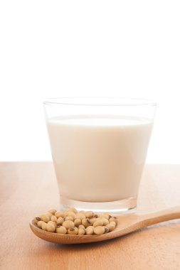 Soya sütü, soya fasulyesi ve tahta kaşık ile cam