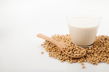 Soya sütü, soya fasulyesi ve tahta kaşık ile cam