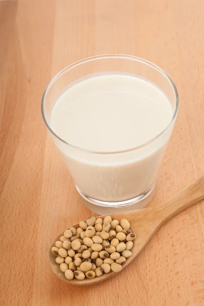 Leche de soja en vaso con soja y cuchara de madera — Foto de Stock