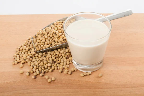 Leche de soja en vaso con soja y cuchara de transferencia —  Fotos de Stock