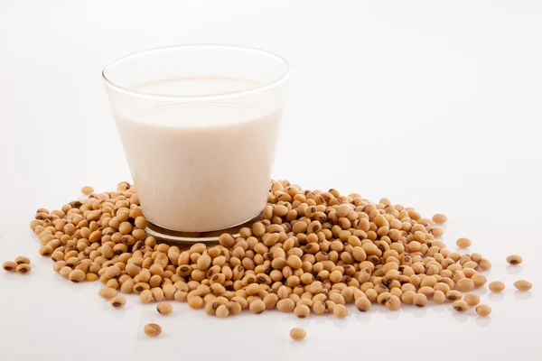 Soy milk in glass with soybeans — Stock Photo, Image