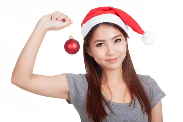 Asiatische Mädchen mit rotem Weihnachtsmann Hut halten Christbaumkugel und lächeln — Stockfoto