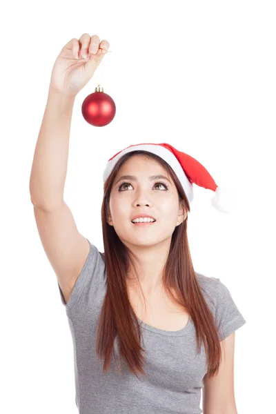 Asiática chica con rojo santa hat mirar arriba en bauble en mano — Foto de Stock