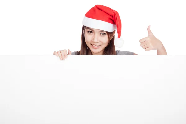 Asian girl with red santa hat show thumbs up with a blank sign — Stock Photo, Image