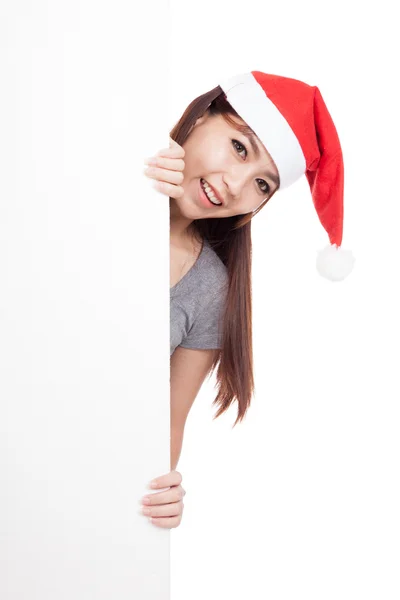 Asiatico ragazza con santa hat peeking da dietro un blank segno — Foto Stock