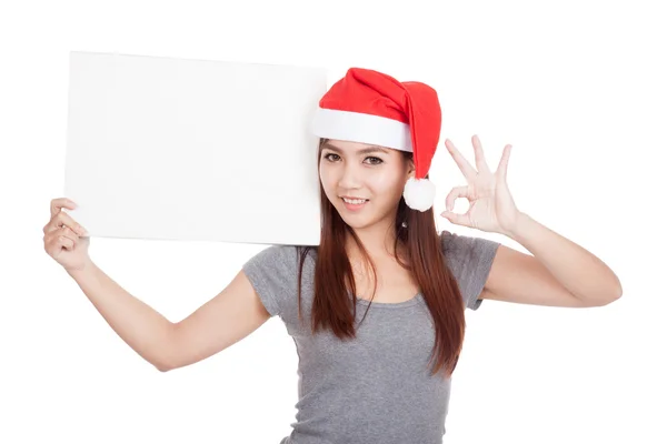 Asiática chica con rojo santa sombrero mostrar OK con un signo en blanco —  Fotos de Stock