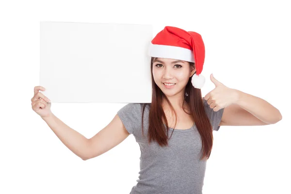 Asian girl with red santa hat thumbs up with a blank sign — Stock Photo, Image