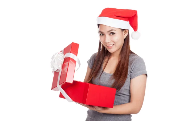 Asiatisches Mädchen mit rotem Weihnachtsmann-Hut öffnet eine Geschenkbox und lächelt — Stockfoto
