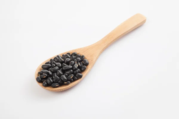 Schwarze Bohnen mit Kochlöffel — Stockfoto