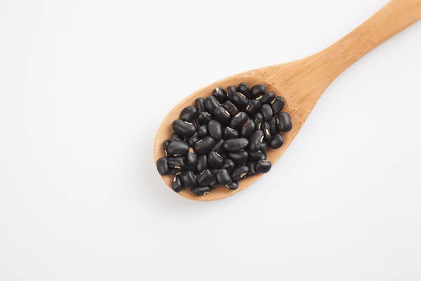 Haricots noirs avec cuillère en bois — Photo