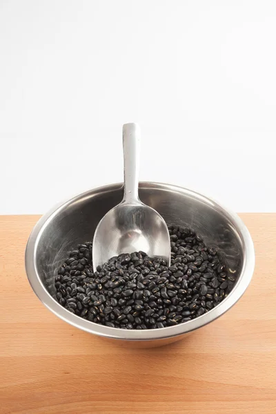 Černé fazole v misce s převodem kopeček — Stock fotografie
