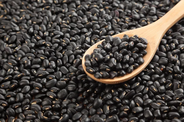 Frijoles negros con cuchara de madera — Foto de Stock