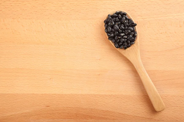 Haricots noirs avec cuillère en bois — Photo