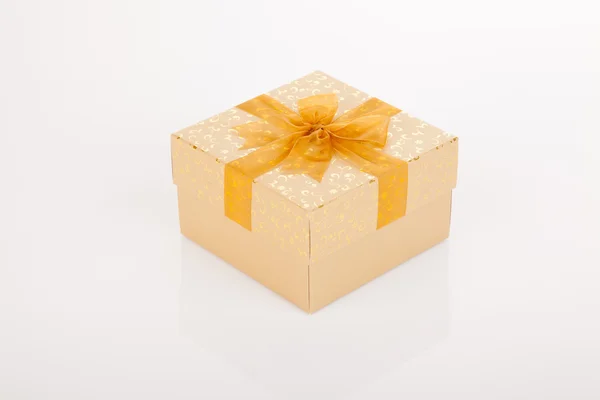 Golden gift box with golden bow on lid — Stock Photo, Image