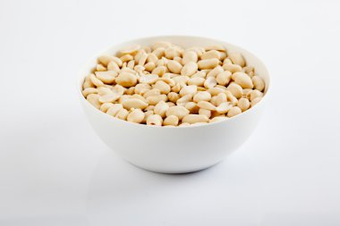 Beyaz bir kase içinde soyulmuş fıstık