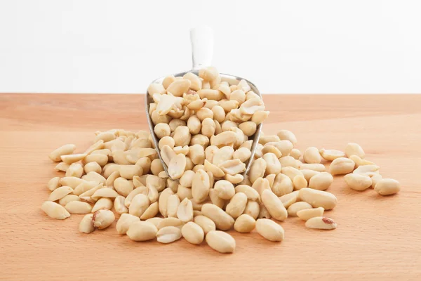 Peeled peanuts with transfer scoop — Stock Photo, Image