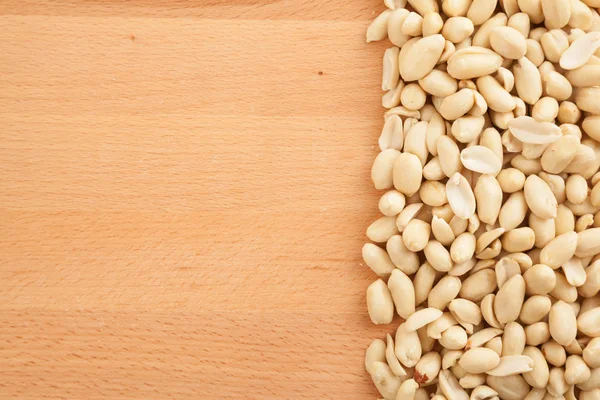 Peeled peanuts on wood background — Stock Photo, Image