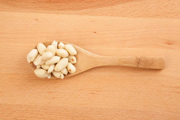 Amendoins descascados com colher de madeira — Fotografia de Stock