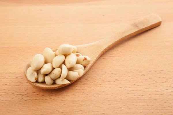 Peeled peanuts with wooden spoon — Stock Photo, Image