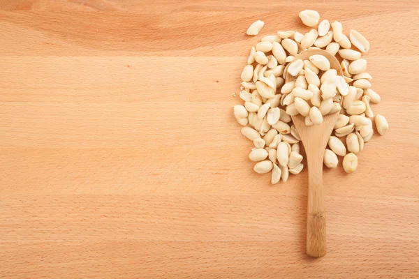 Peeled peanuts with wooden spoon — Stock Photo, Image