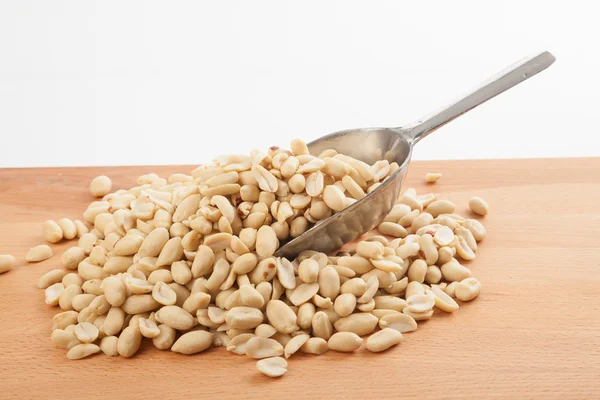 Peeled peanuts with transfer scoop — Stock Photo, Image