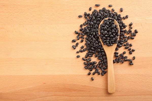 Frijoles negros con cuchara de madera — Foto de Stock