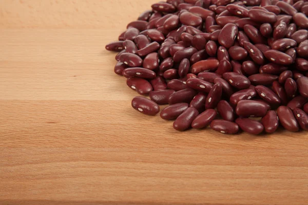 Frijoles rojos sobre mesa de madera — Foto de Stock