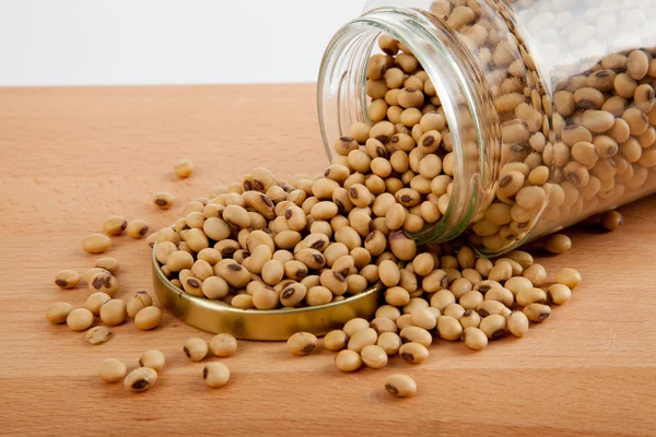 Soybean in a jar with lid off on wood table — Stock Photo, Image