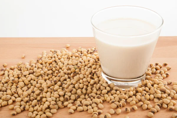 Soy milk in glass with soybeans — Stock Photo, Image