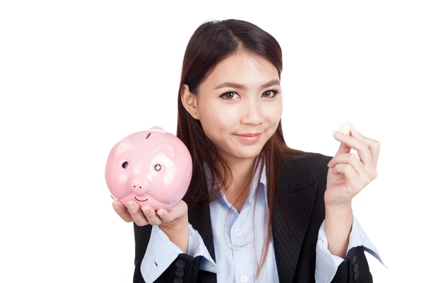 Jonge Aziatische zakenvrouw met een munt en piggy bank — Stockfoto