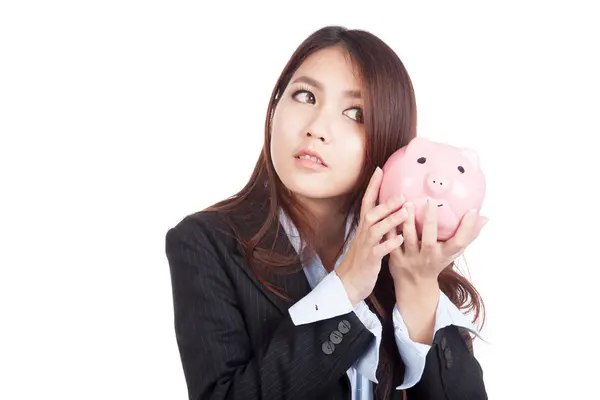 Young Asian businesswoman listen to piggy bank — Stock Photo, Image