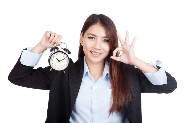 Young Asian businesswoman show OK with alarm clock — Stock Photo, Image