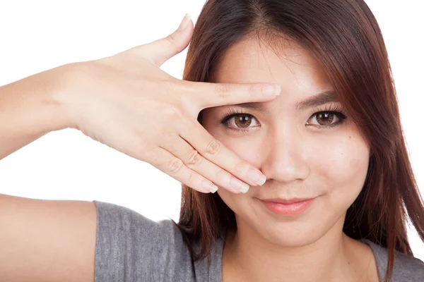 Junge asiatische Frau lächelt guckend durch ihre Finger — Stockfoto