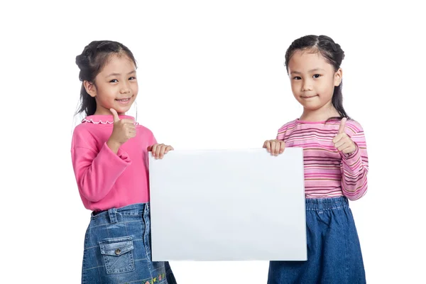 Aziatische tweelingzusjes houden een leeg teken Toon duimen omhoog — Stockfoto