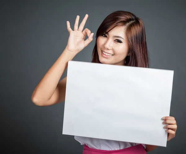 Gelukkig Aziatisch meisje houdt leeg teken Ok teken weergeven — Stockfoto