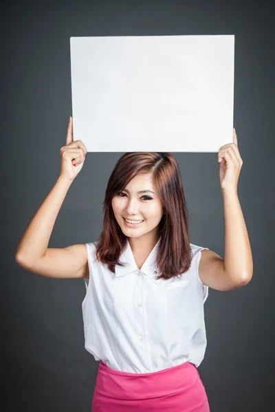 Asiática chica hold en blanco signo sobre su cabeza y sonrisa — Foto de Stock