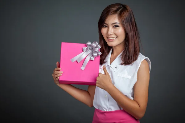 Linda menina asiática polegares para cima com uma caixa de presente — Fotografia de Stock