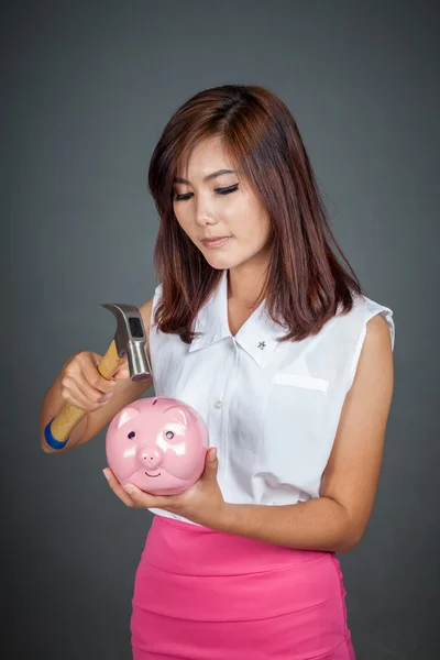 Beautiful Asian girl about to hit money box with hammer — Stock Photo, Image