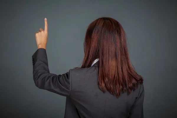 Achterkant van Aziatische zakenvrouw aanraken van het scherm met haar vinger — Stockfoto