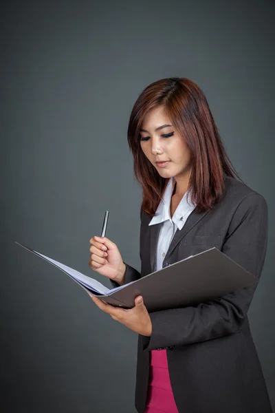 Азиатская бизнесвумен с ручкой и папкой — стоковое фото