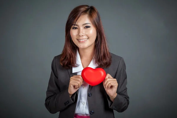 快乐的亚洲女商人在她胸口上显示红色的心 — 图库照片