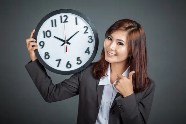 Asiática mujer de negocios sostener un reloj pulgares arriba y sonrisa —  Fotos de Stock