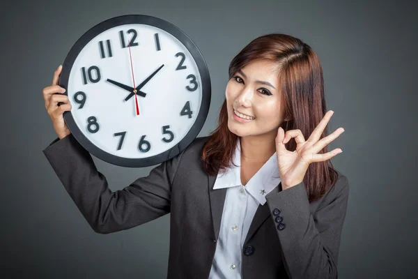 Asiatische Geschäftsfrau halten eine Uhr zeigen ok Zeichen und Lächeln — Stockfoto