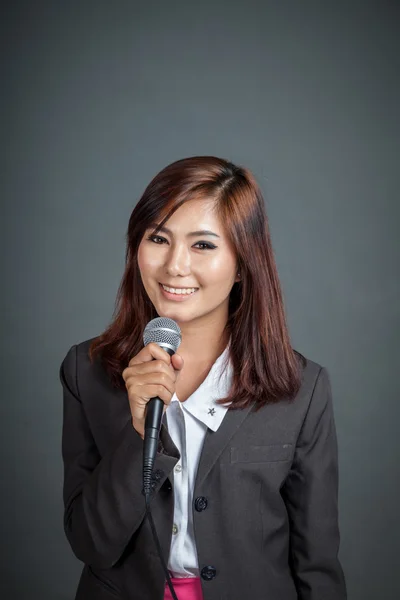 Asian business girl hold a microphone and smile — Stock Photo, Image