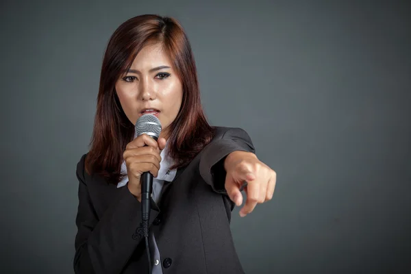 Enojado asiático negocio chica hold un micrófono y punto — Foto de Stock