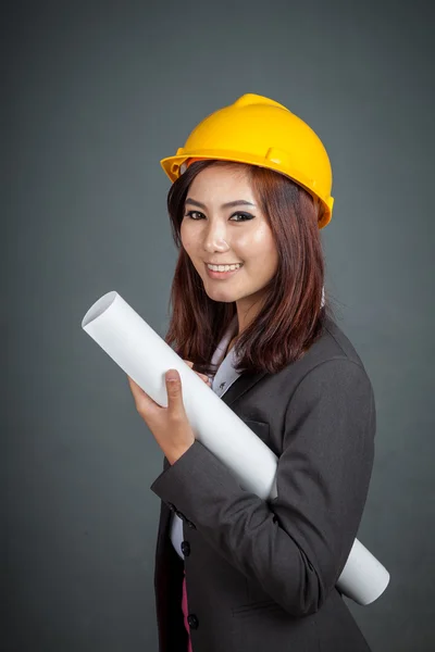 Aziatische ingenieur meisje houdt een blauwdruk en glimlach — Stockfoto