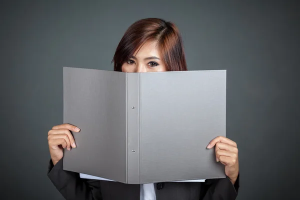 Asian businesswoman close her lower face  with a folder Stock Picture
